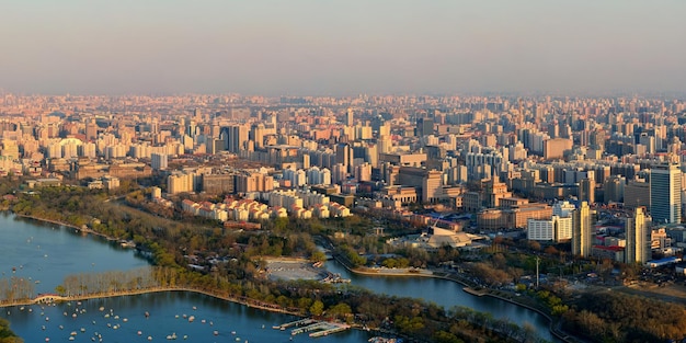 Beijing sunset aerial view with urban buildings and lake.