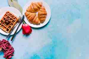 Free photo belgian waffle with croissants and flowers