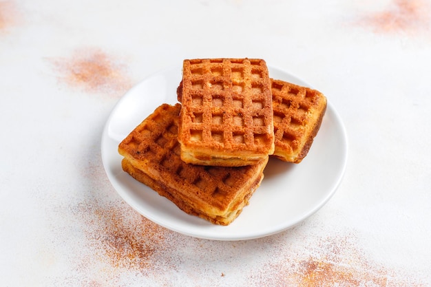 Belgian waffles with cream and fresh raspberries.