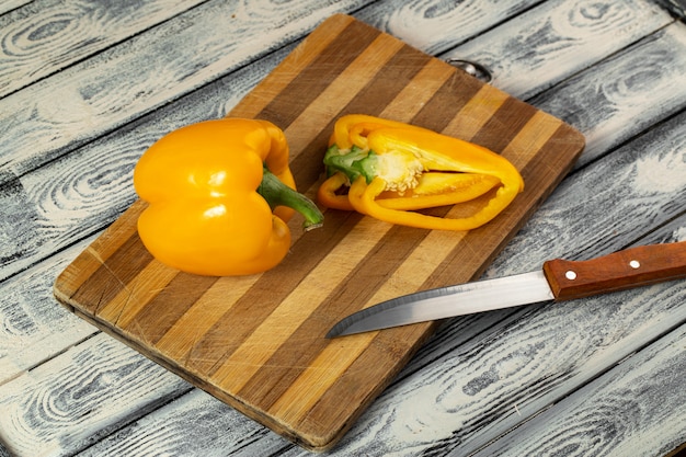 Bell pepper yellow fresh ripe and sliced on brown wooden desk and grey background