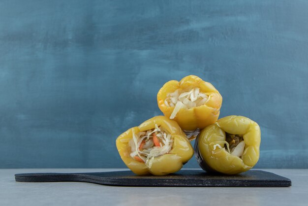 Bell peppers stuffed with sauerkraut on the cutting board on the marble surface