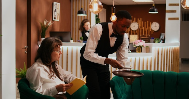 Free Photo bellhop serving coffee cup to woman