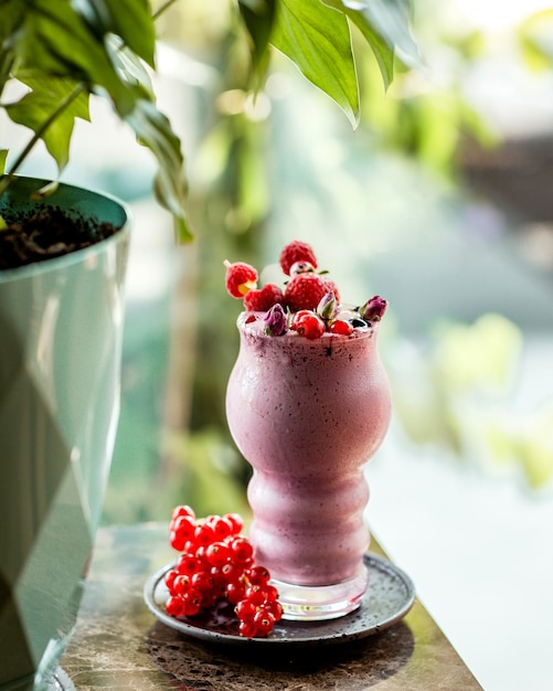 Free photo berries milkshake garnished with raspberry strawberry and cranberries in bamboo skewers