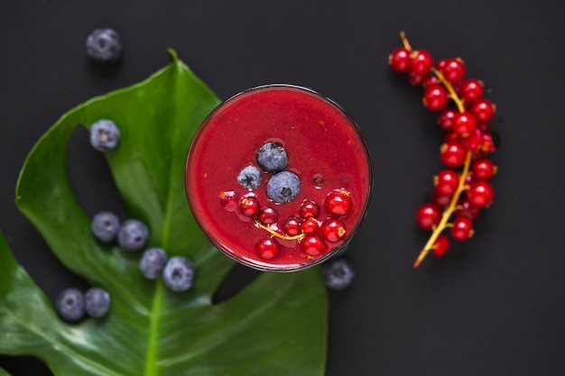 Free Photo berries smoothies on leaf against black background