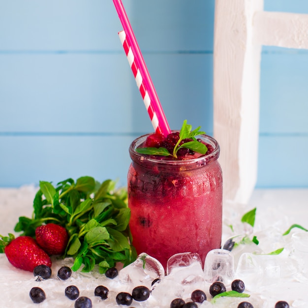 Berry cocktail with strawberry, raspberry and ice in glass jar