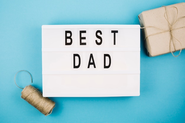 Free photo best dad title on tablet near present box and thread