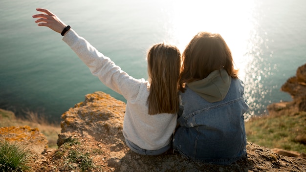 Free Photo best female friends hugging each other and ocean