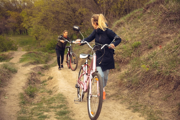 Free photo best friend having fun near seaside countryside park, riding bikes