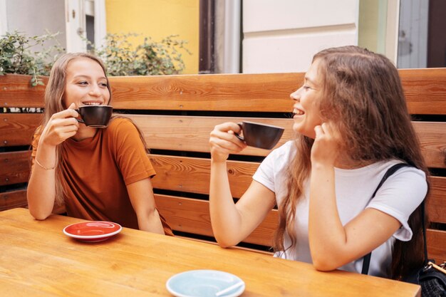 Best friends drinking coffee together outdoors