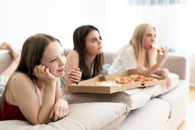 Best friends eating pizza at home