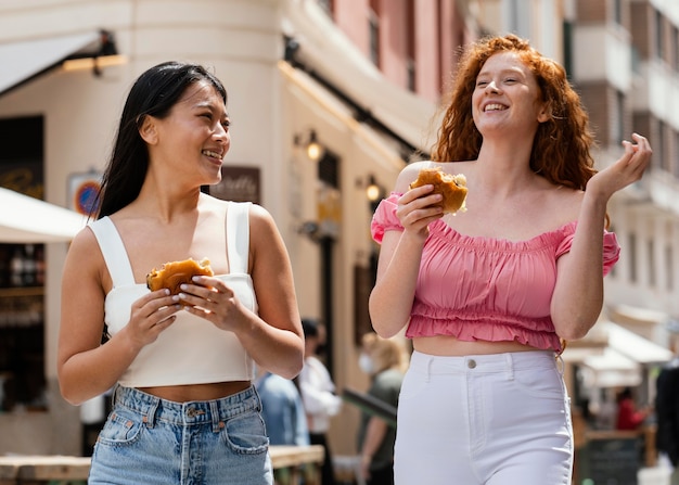 Free photo best friends eating together some street food