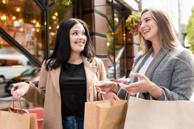 Best friends holding shopping bags