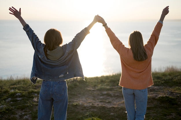 Free Photo best friends holding their hands in the air