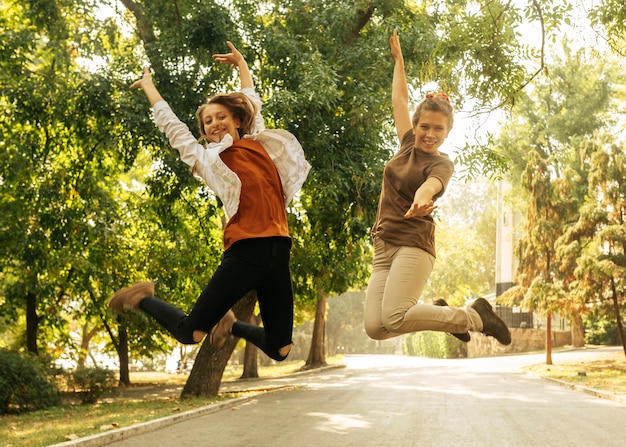 Free photo best friends jumping outdoors