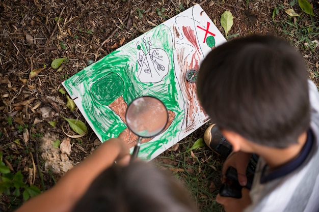 Free photo best friends participating in a treasure hunt outdoors