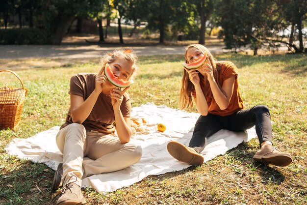 Best friends posing while eating watermelon