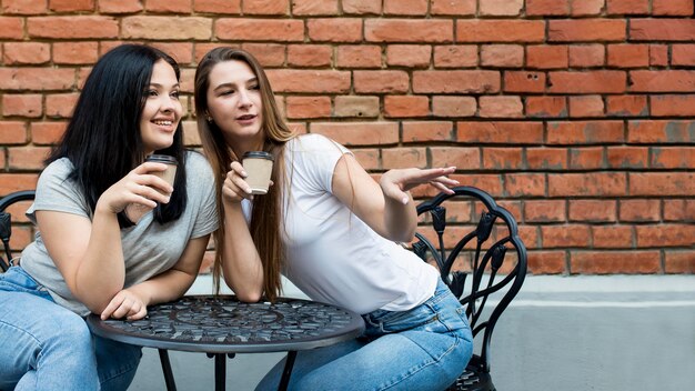 Best friends taking their coffee together with copy space