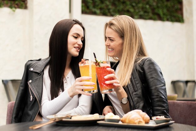 Best friends toasting with cocktails