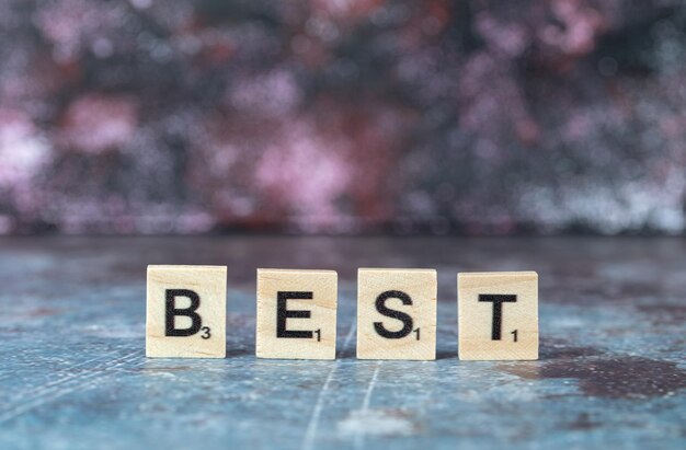 Best writing with black letters on wooden dices on blue background. High quality photo