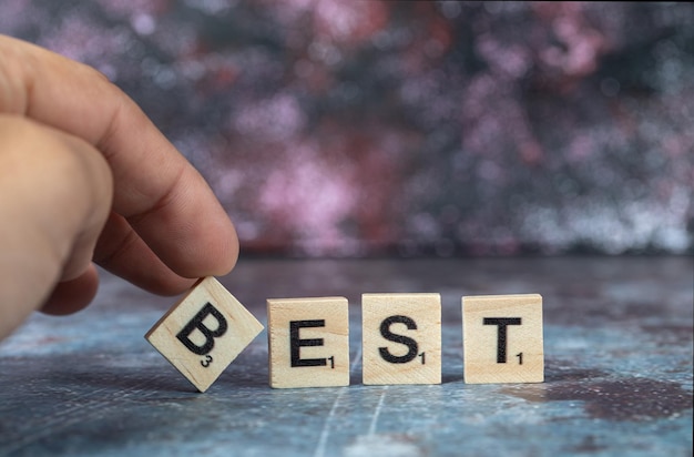 Best writing with black letters on wooden dices on blue background. High quality photo