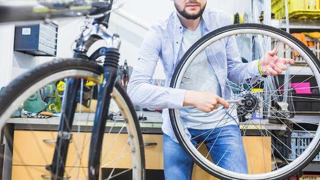 Free photo bicycle mechanic repairing bicycle tire with wrench