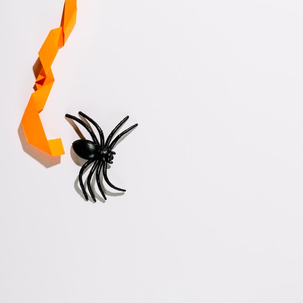 Big black spider with orange paper decoration