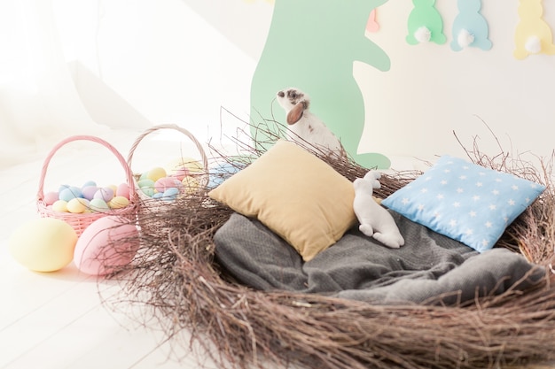 Big easter nest with pillows. eggs and rabbit.