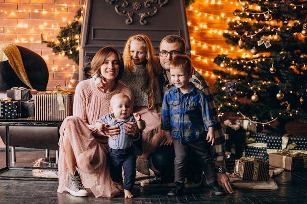 Big family on Christmas eve with presents by Christmas tree