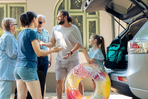 Big family leaving on seaside holiday with vehicle trip, small child with grandparents and parents travelling on vacation journey during summer. People feeling excited about sea destination.