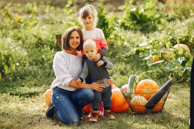 Big family sitting on a garden near many pumpkins