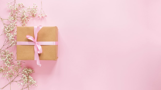 Big gift box with flower branches on table