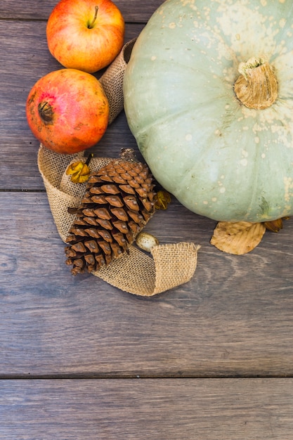 Free photo big green pumpkin with fruits on table