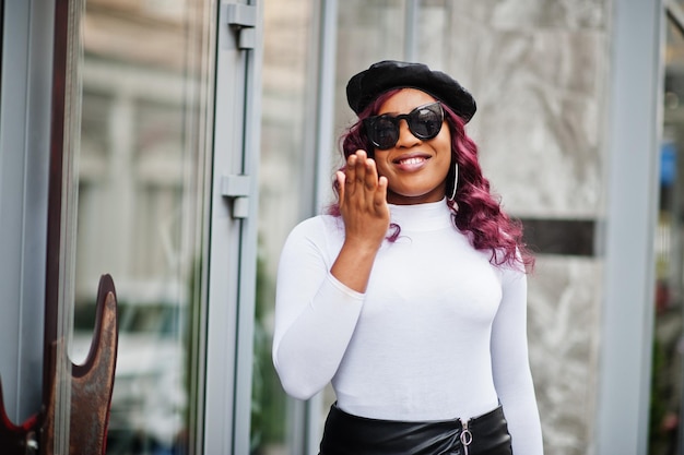 Free photo big mama plus size african american model in black sunglasses beret and leather skirt posed outdoor and send air kiss