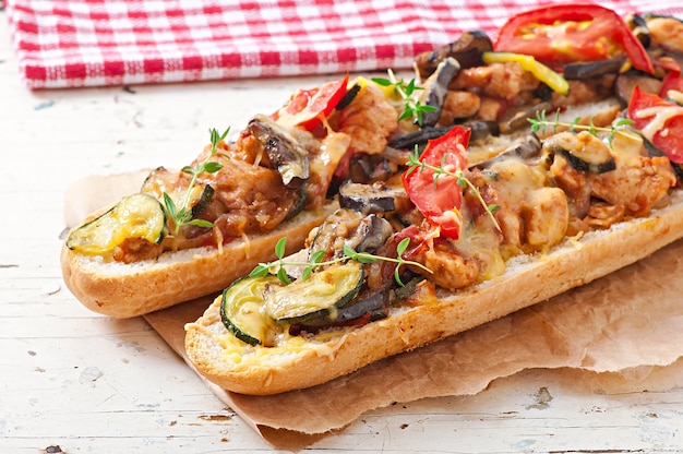 Big sandwich with roasted vegetables (zucchini, eggplant, tomatoes) with cheese and thyme