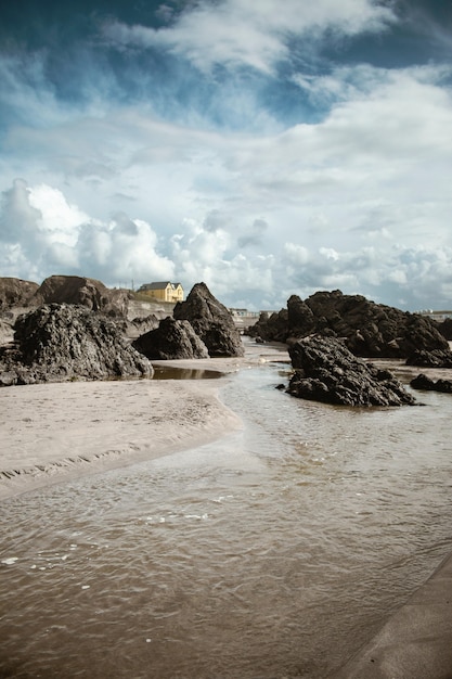 Big stones and wet sand on the beach during daytime