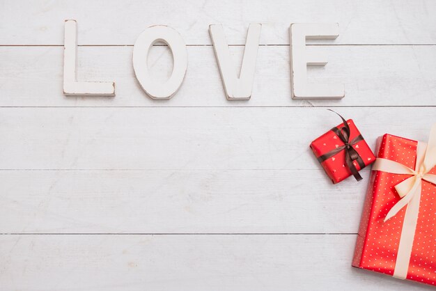 Big white love title near gift boxes