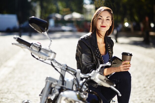 Biker girl in a leather jacket on a motorcycle