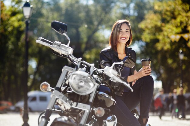 Biker girl in a leather jacket on a motorcycle