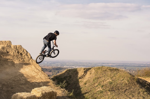 Biker jumping and flying over a hill