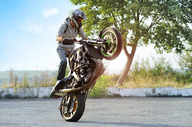 Biker making tricks on sport motorcycle on the street