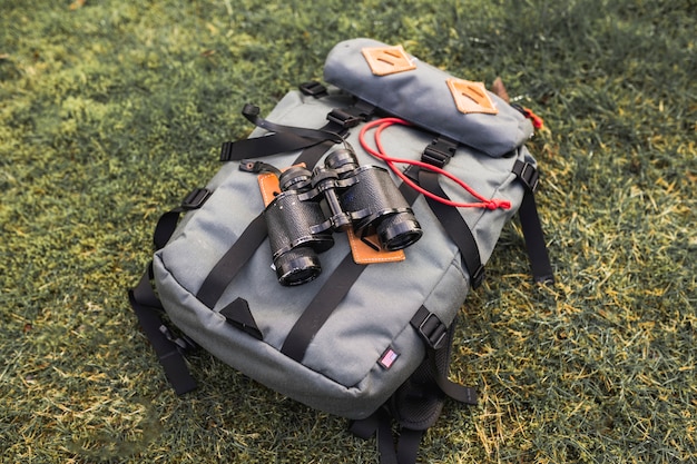 Free photo binoculars and backpack on grass