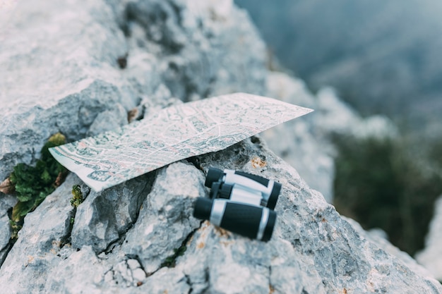 Free photo binoculars and map on rock