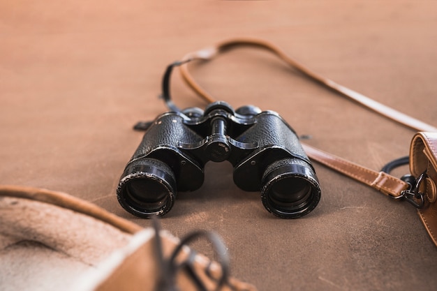 Free photo binoculars between shoes and bag