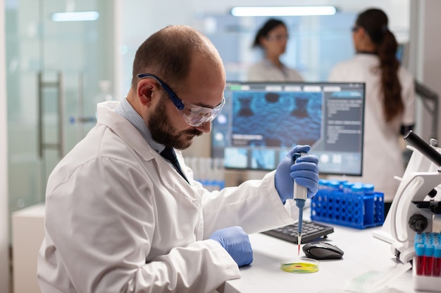 Free photo biochemistry health care scientist testing blood sample using micropipette