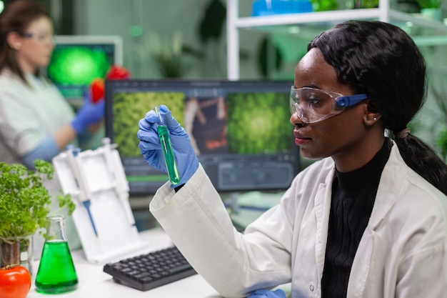 Free photo biologist holding test tube with genetic liquid examining green dna sample for biochemistry expertise