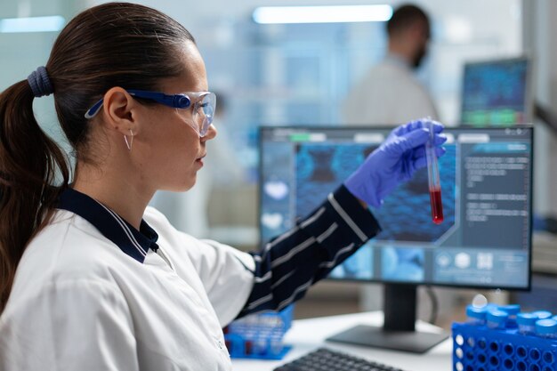 Biologist researcher holding blood test tube analyzing dna medical expertise