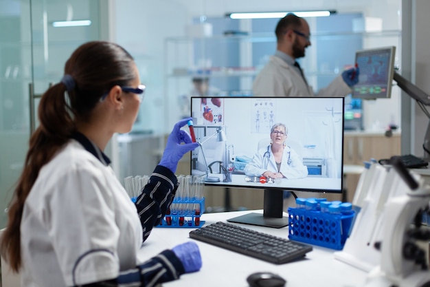 Free photo biologist researcher woman holding blood test tube in hands discussing medical vaccine