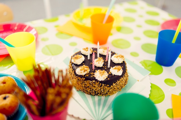 Free photo birthday cake on table with colored glasses