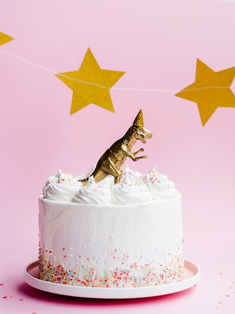 Free Photo birthday cake with dinosaur and golden stars