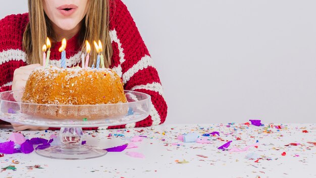 Birthday concept with girl blowing out candles